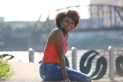 Smiling Black Woman Sitting near River