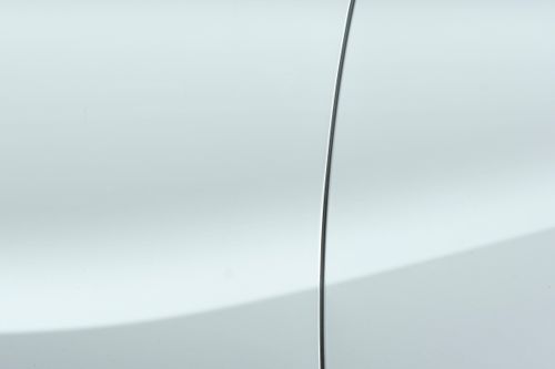 Free A minimalistic close-up showcasing the smooth and shiny surface of a white car with a sleek panel line. Stock Photo