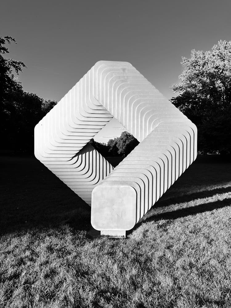 Black And White Picture Of A Modern Sculpture In A Park 