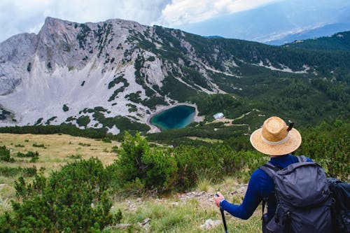 Person in Hat Hiking in Mountains