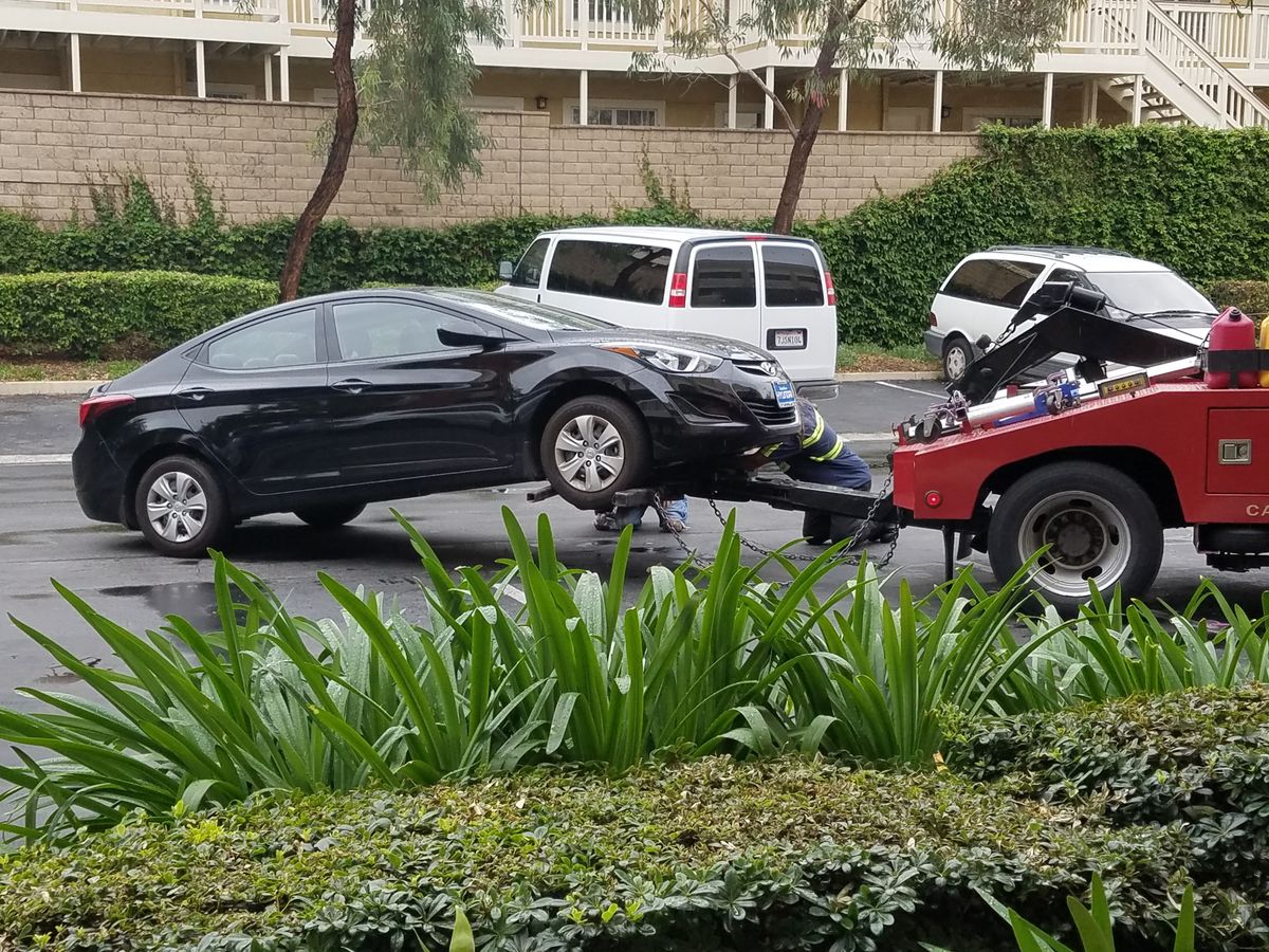 Car with a flat tire awaiting a tow truck