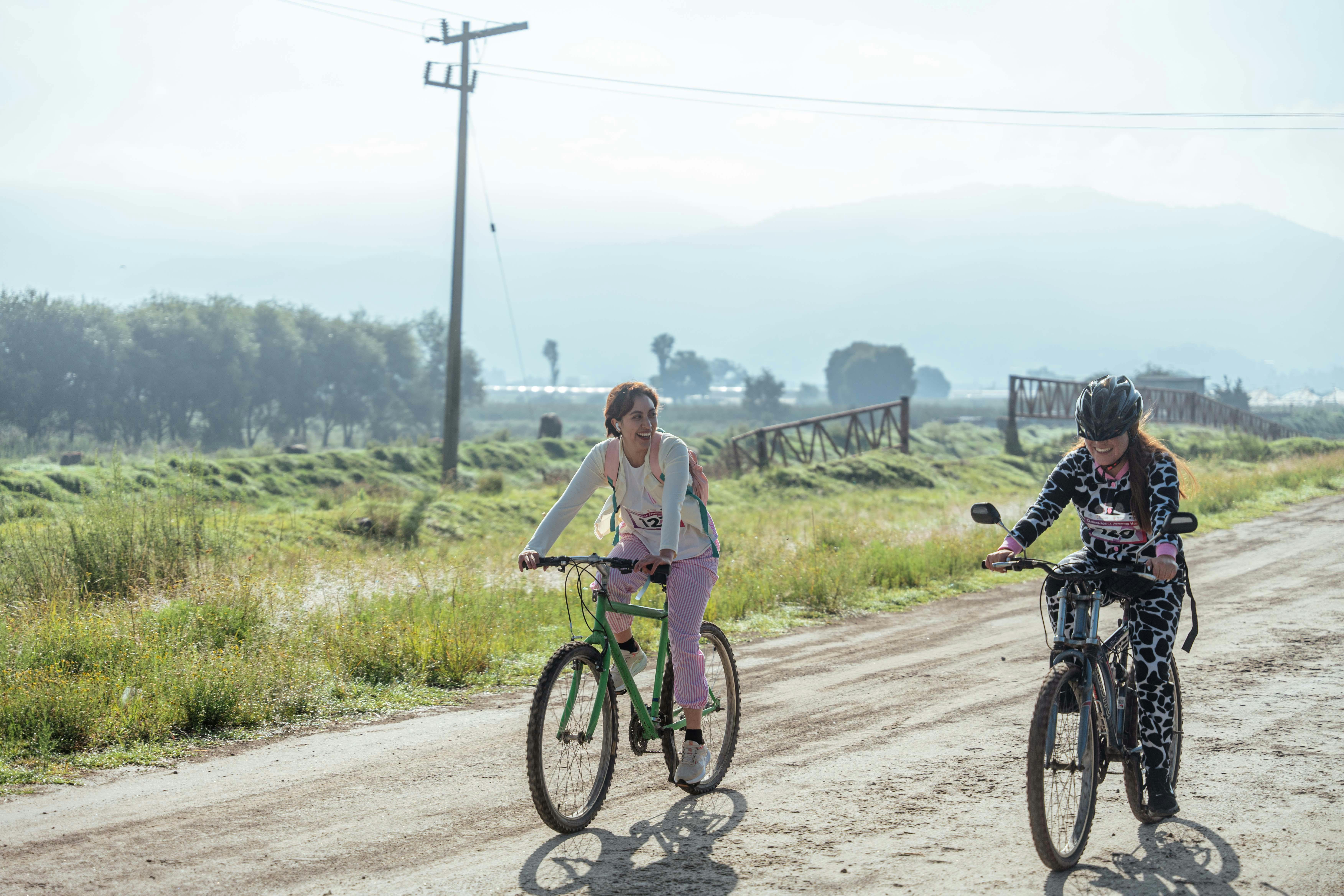 Women Riding Bikes in Race on Dirt Road Free Stock Photo