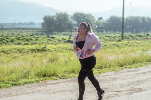 Free Female runner participating in an outdoor marathon race during the day. Stock Photo