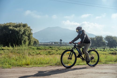 Man in Helmet and Goggles Riding Bicycle