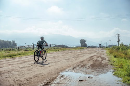 Boy Riding Bike on Dirt Road