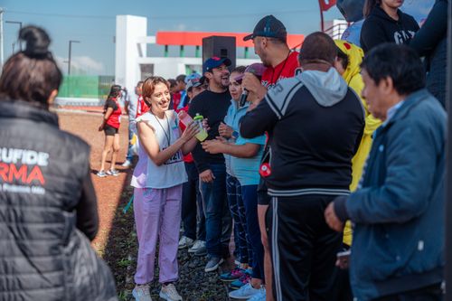Free Group of adults engaging in an outdoor team-building event, sharing drinks and laughter. Stock Photo