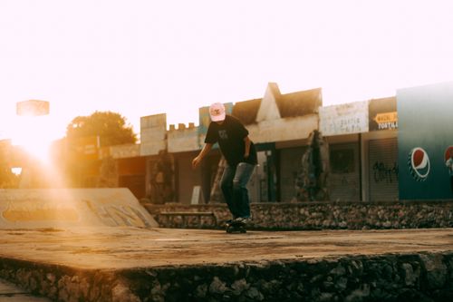 Free Dynamic shot of a man skateboarding in an urban skatepark at sunset, capturing motion and ambient light. Stock Photo