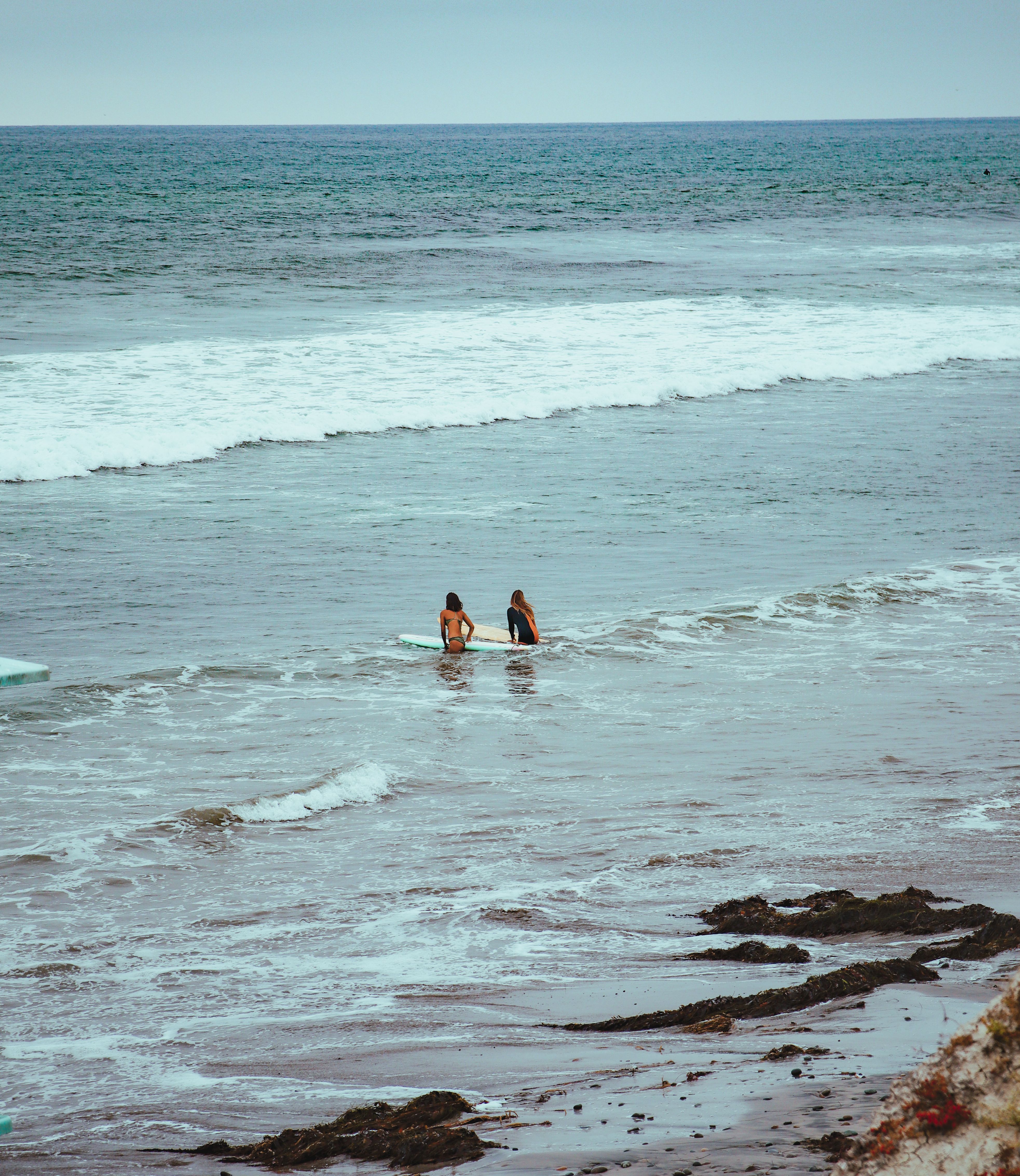 Two swimmers in the ocean shallows on a clear day — photo by Ant Armada on Pexels