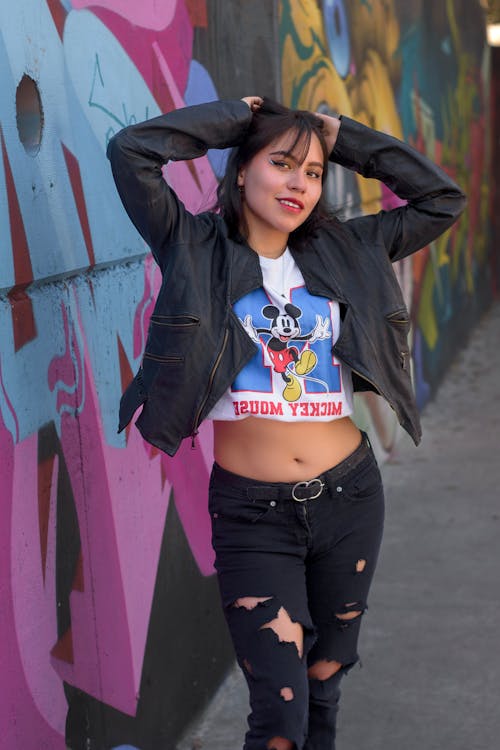 Young Woman Posing near Graffiti Wall