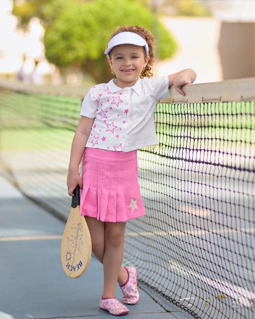 Free Smiling Girl with Racket Posing near Net on Court Stock Photo