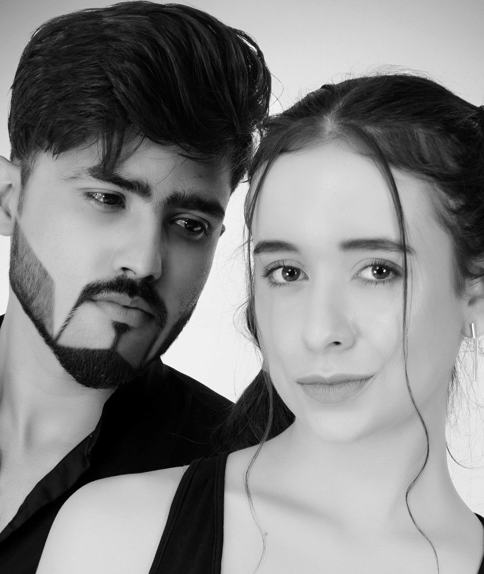 Expressive black and white studio portrait of a young couple showcasing emotions.