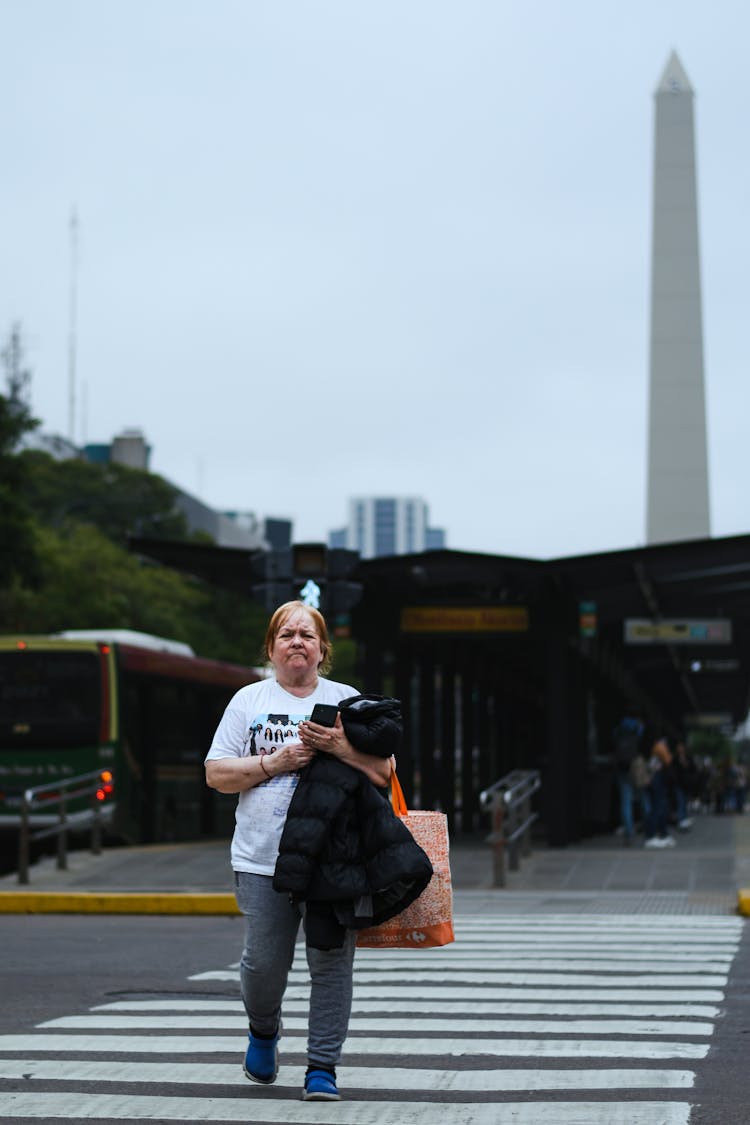 Old Woman Walking On Crossing On City Road