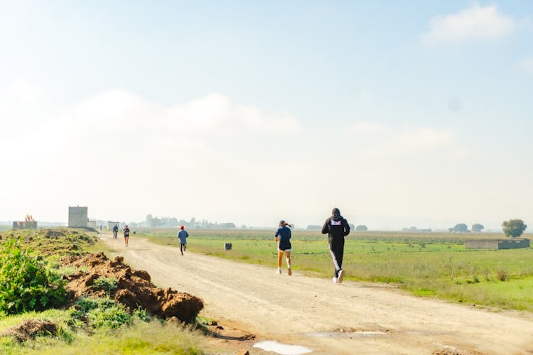 People Running On Dirt Road