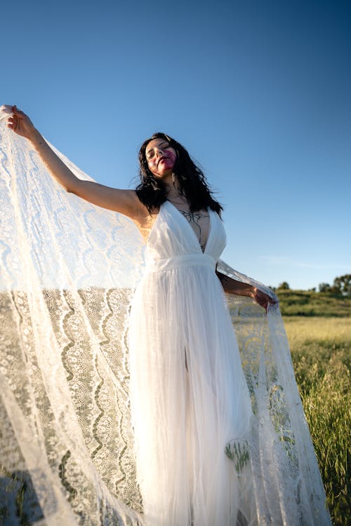 Young Woman in White Dress Posing in Field