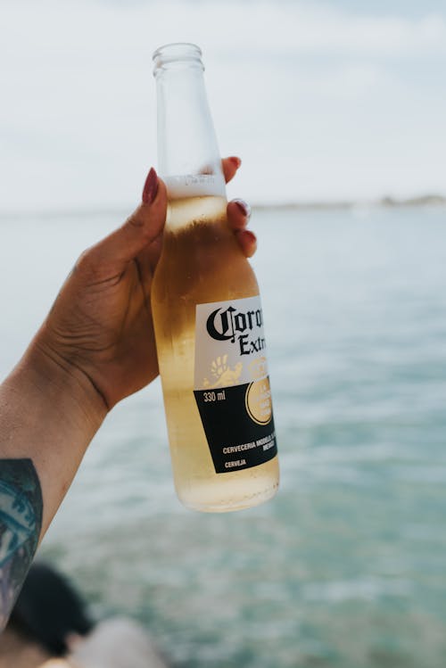 Woman Holding Beer on a Beach