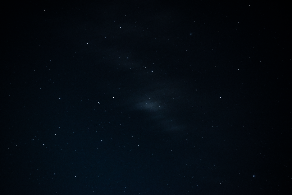 Fotomural Una vista impresionante del cielo nocturno estrellado que muestra constelaciones y galaxias distantes.