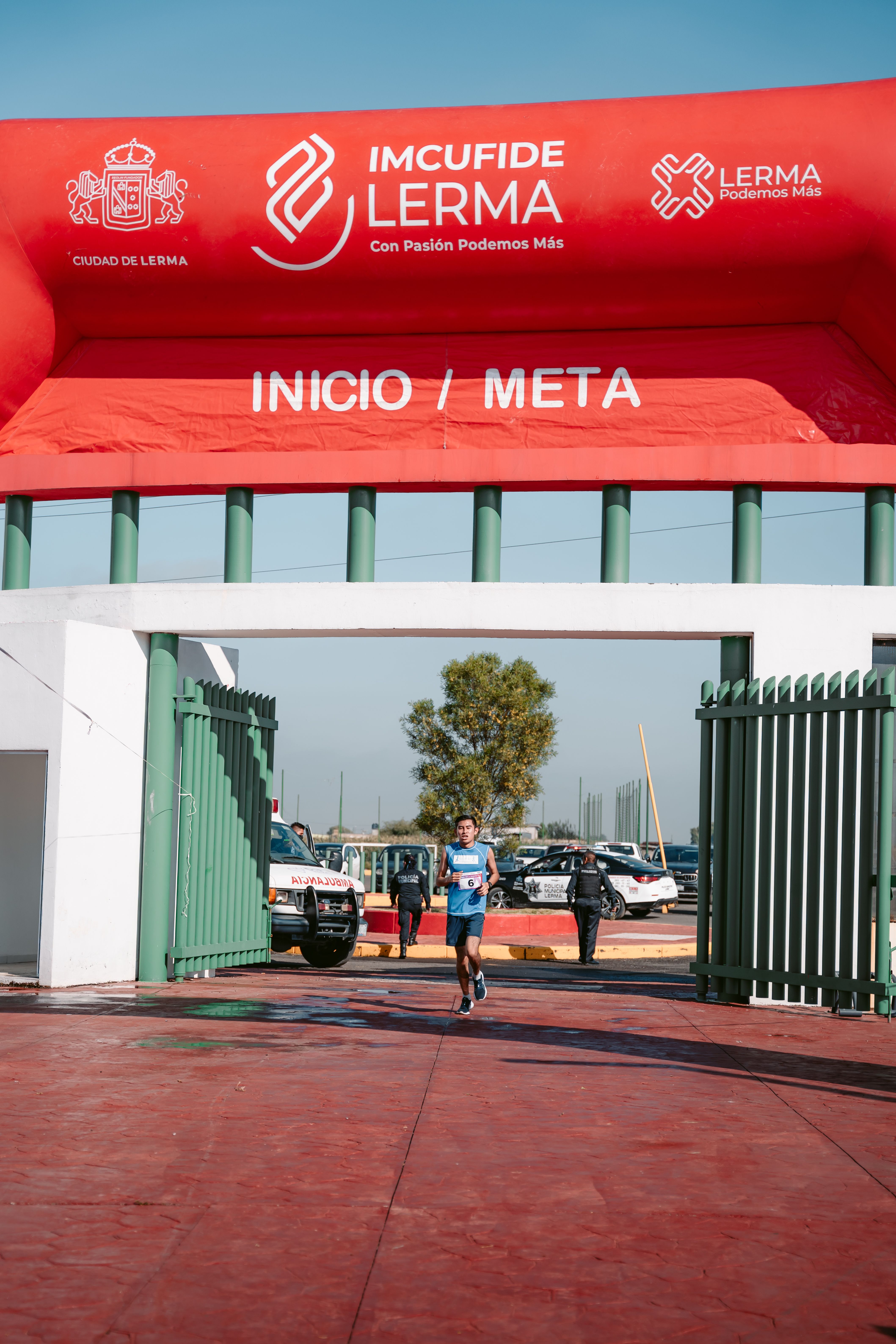 A Man Running through the Finishing Line with a Gate at the Marathon ...
