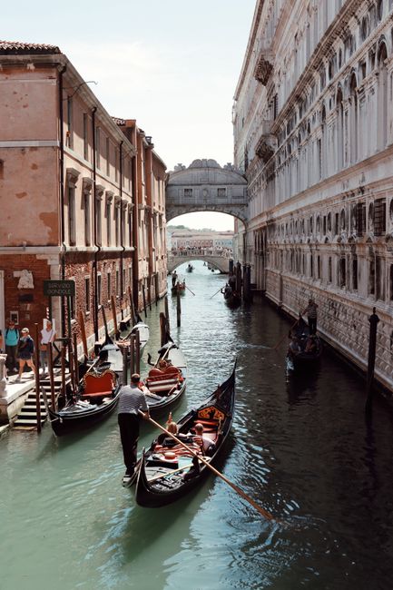 Picturesque view of gondolas under the Bridge of Sighs in Venice, Italy, capturing iconic architecture and serene canal.
