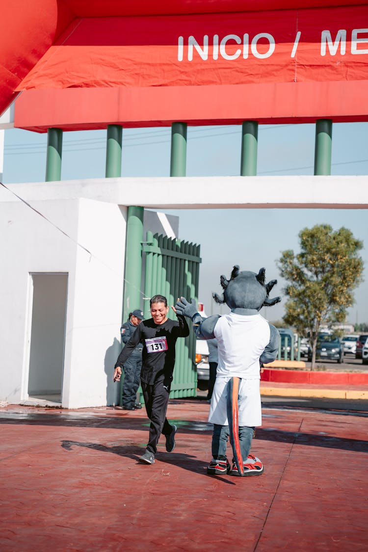 Runner Giving High Five Mascot On Meta