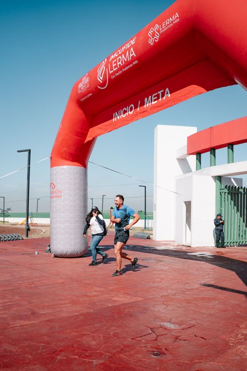 Running Finish Gate Woman Taking Pictures of Man Running through Start and Finish Gate ...