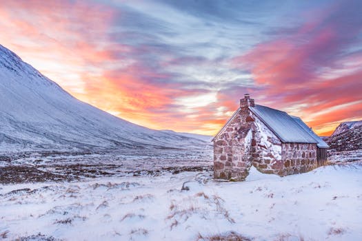 Beautiful sunrise over a snow-covered bothy in the Cairngorms, Scotland.