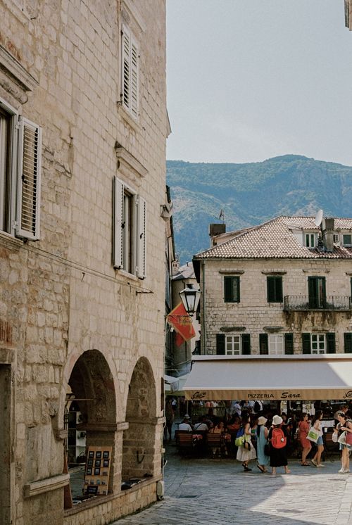 Free Picturesque street scene in an old town with tourists, historic buildings, and summer vibe. Stock Photo