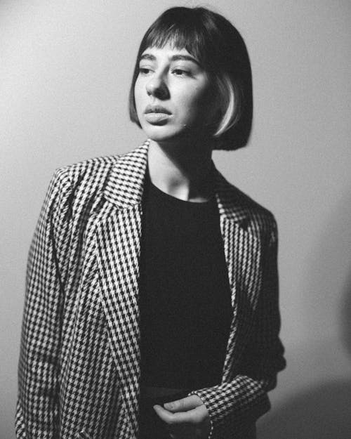 Black and White Photo of a Woman Wearing a Checked Jacket