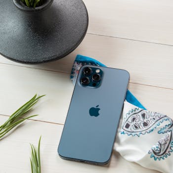 Stylish smartphone on a wooden table with a bandana and plant.