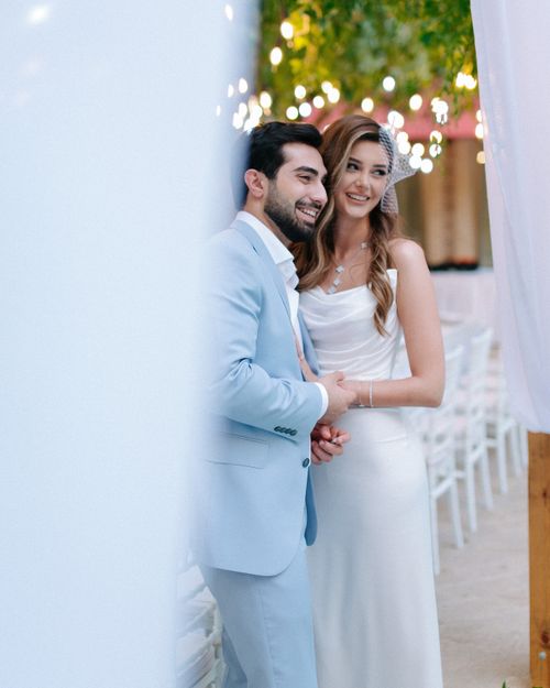 Free Smiling bride and groom in elegant attire at an outdoor wedding ceremony. Stock Photo