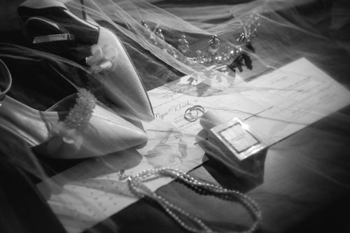 Free Black and white photo capturing bridal accessories including shoes and jewelry. Stock Photo