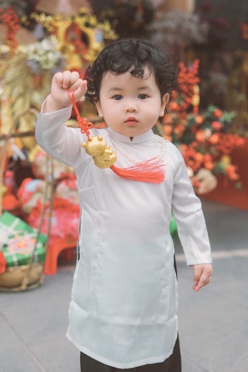 Photo of a Baby Girl with Curly Hair Playing with a Festive Decoration