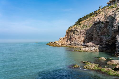 Free Beautiful rocky coastline with serene blue ocean and clear skies, perfect for a summer getaway. Stock Photo