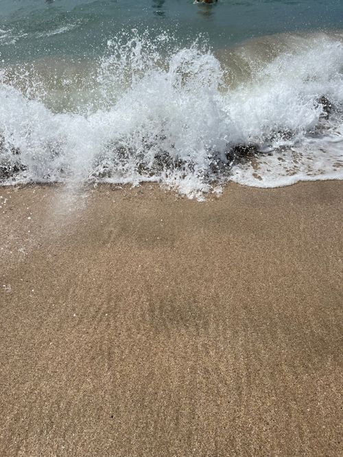 Free Close-up of ocean waves breaking on a sandy beach, capturing the dynamic motion of water. Stock Photo