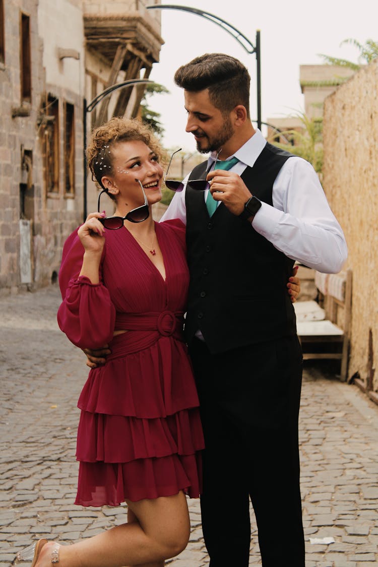 Smiling Couple In Elegant Clothes Standing On Paving Street