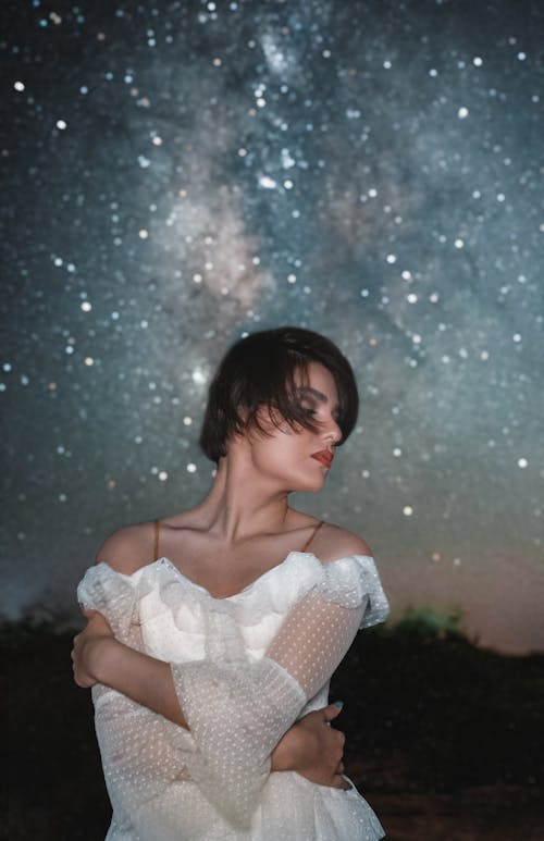 Model in a White Off-the-shoulder Dress Under the Starry Sky