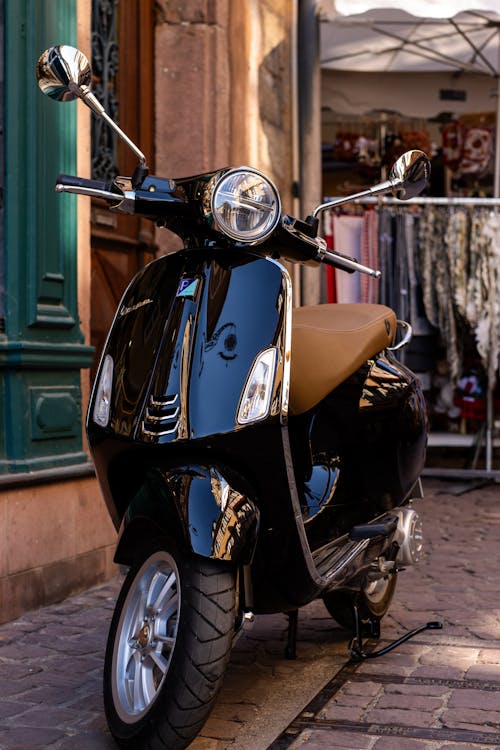 A Motor Scooter Parked on the Pavement 