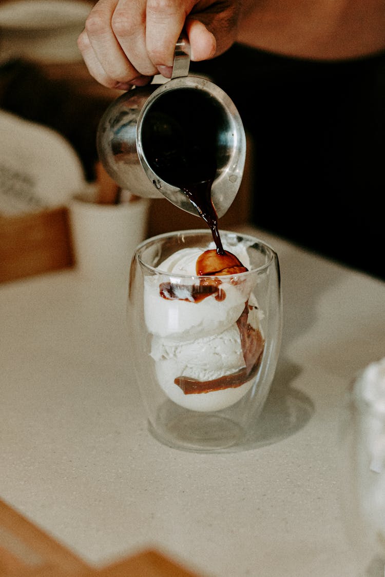 Person Pouring Coffee On Ice Creams