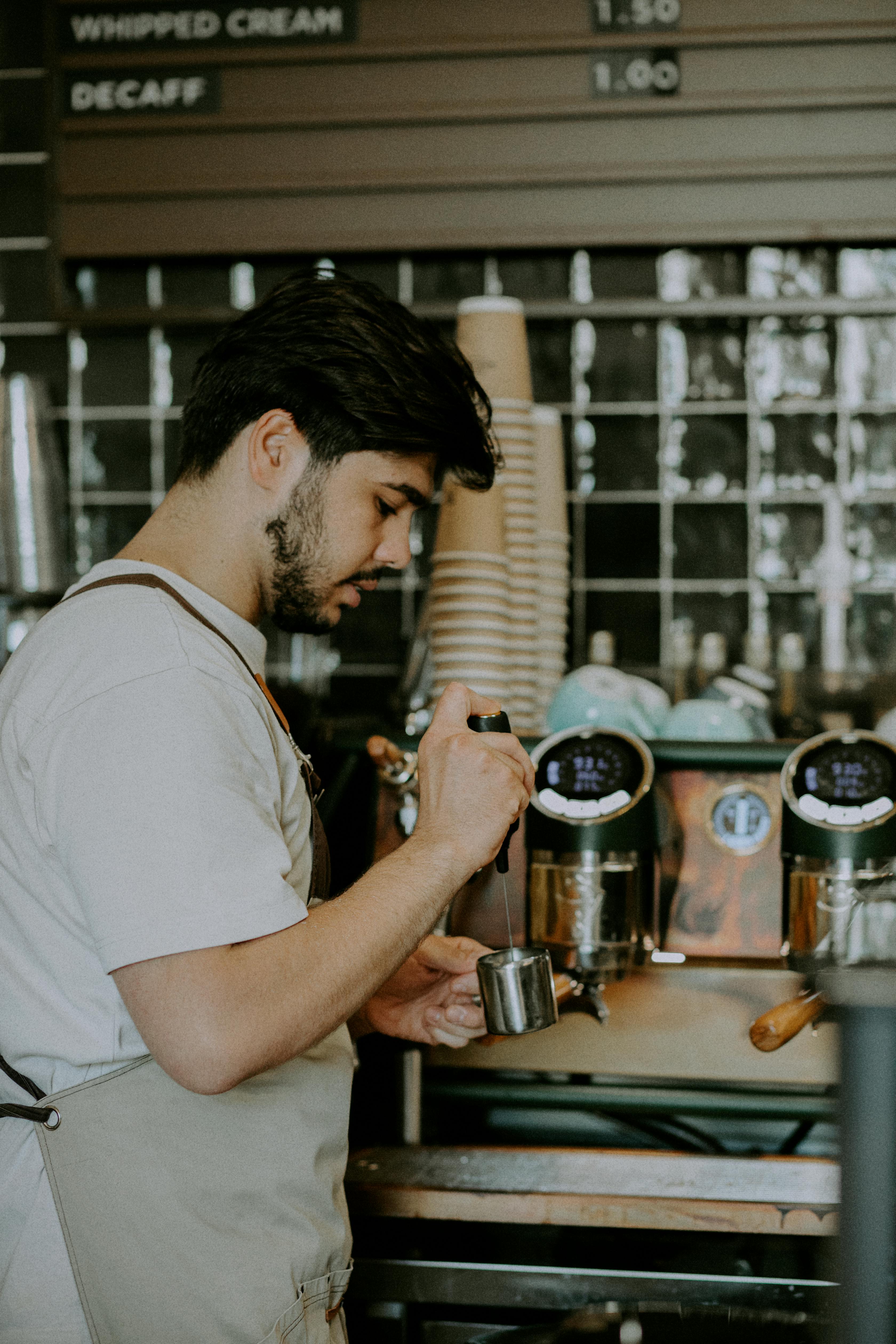 Barista making espresso in a Baku café, showcasing coffee preparation skills.