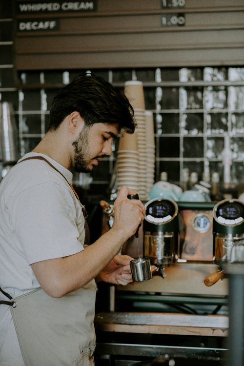 Free Barista making espresso in a Baku café, showcasing coffee preparation skills. Stock Photo