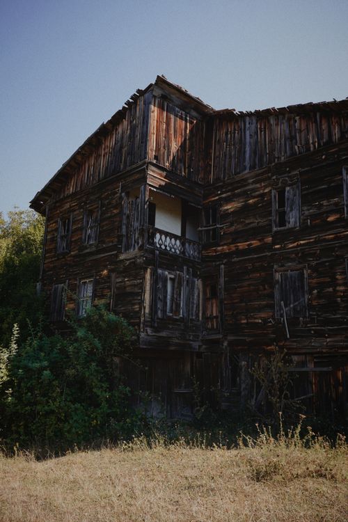 Free Explore the charm of a rustic abandoned wooden house amidst a tranquil countryside setting. Stock Photo