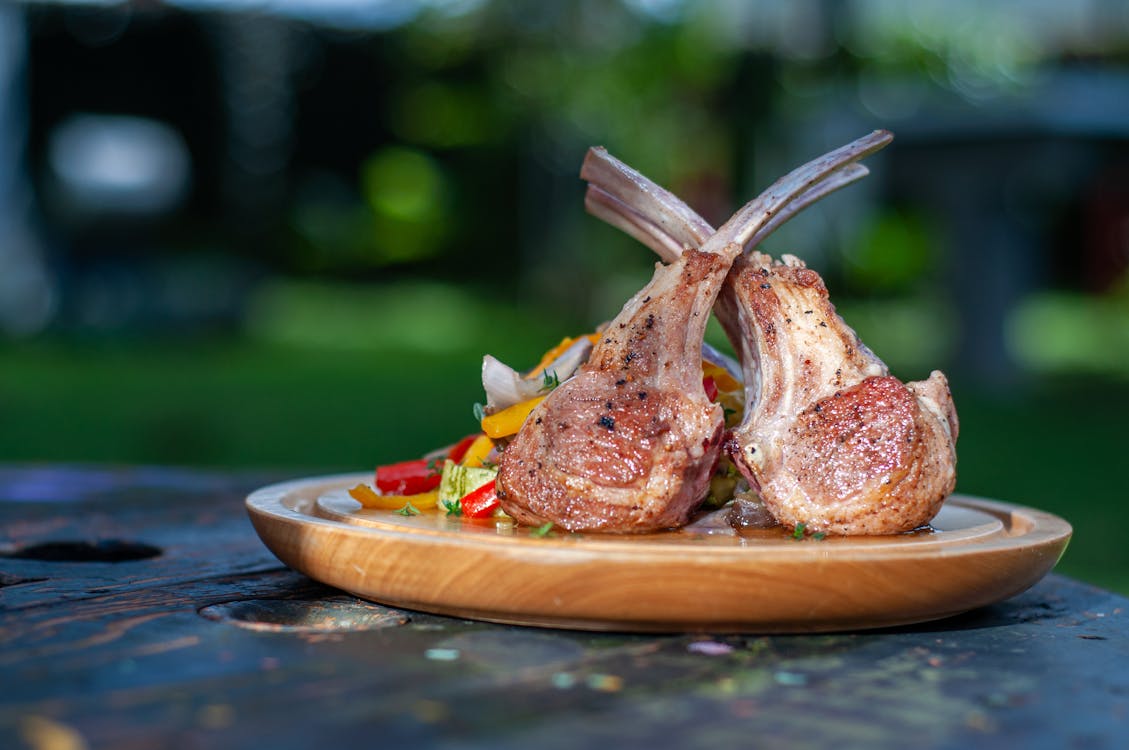 Wooden Plate of Roasted Lamb Chops with Vegetables · Free Stock Photo
