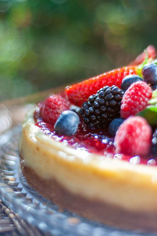 Free Close-up of a vibrant berry cheesecake topped with fresh fruits in natural light. Stock Photo