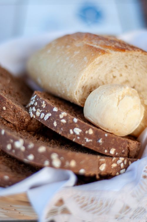 Free A close-up view of assorted artisan bread in a basket, showcasing textures and grains. Stock Photo