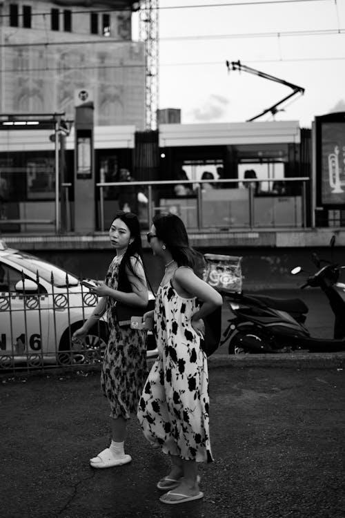 Women in Floral Dresses and Lip Flops Walking on Sidewalk