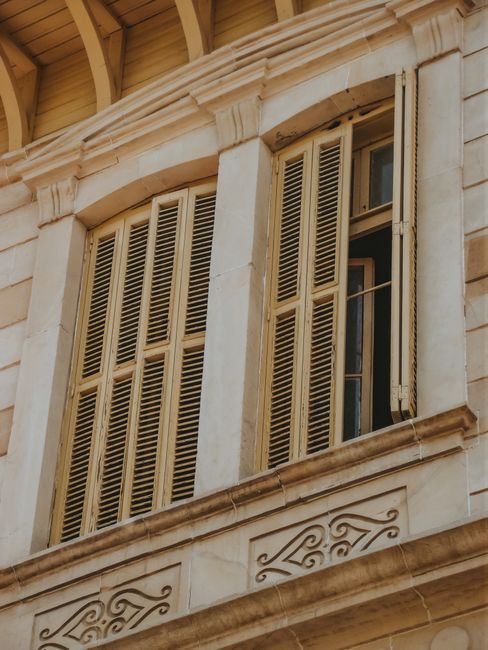 Close-up of an architectural facade showcasing vintage wooden shutters on a stone building.