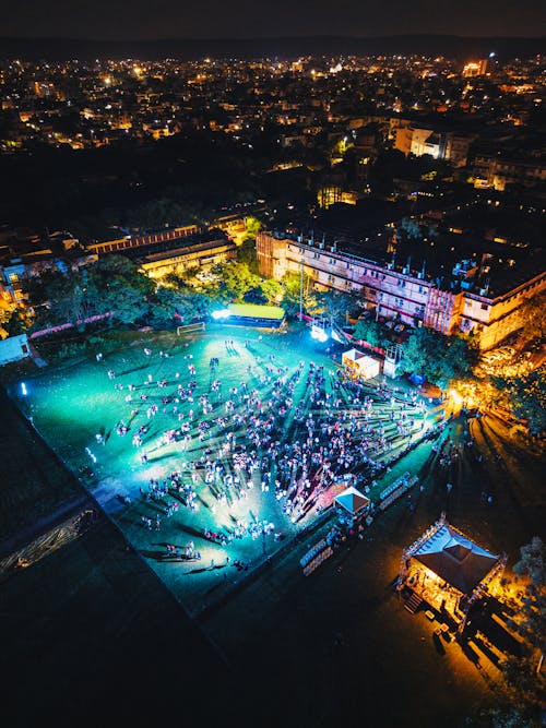 Aerial View of People Gathered on an Illuminated Square in City at Night 