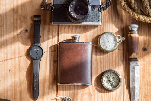 Lomo相機手錶刀和able懷錶附近的棕色酒瓶