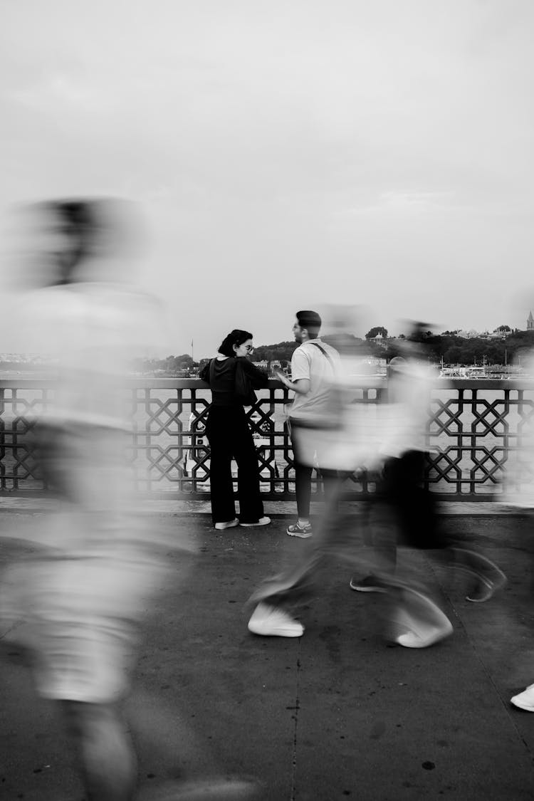 Woman And Man Among People Walking On Galata Bridge