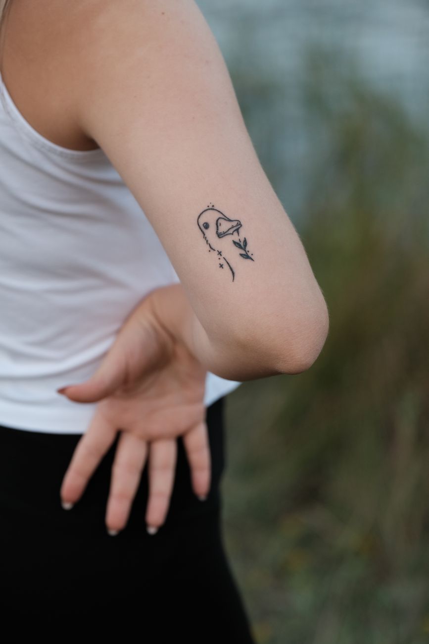 Woman wearing a small delicate temporary tattoo on her arm outdoors