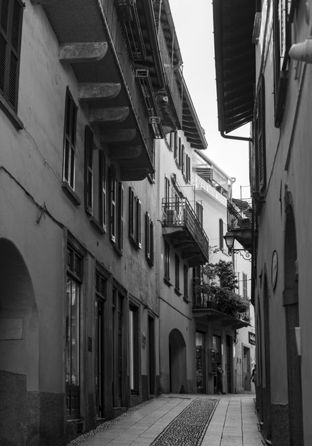 A narrow urban alleyway showcasing quaint architecture in black and white.